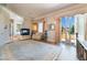 Sunlit main bedroom featuring a fireplace, balcony access, and wood flooring at 5186 San Milano Ave, Las Vegas, NV 89141