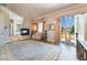 Sunlit main bedroom featuring a fireplace, balcony access, and wood flooring at 5186 San Milano Ave, Las Vegas, NV 89141