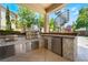 Outdoor kitchen with stainless steel grill, refrigerator, and tile backsplash, perfect for entertaining at 5186 San Milano Ave, Las Vegas, NV 89141