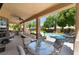 Spacious covered patio featuring an outdoor kitchen, comfortable seating, and views of the pool at 5186 San Milano Ave, Las Vegas, NV 89141