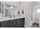 Bathroom features a large mirror over a dark-stained vanity and a shower/tub combo at 5255 Peak Rock Ct, Las Vegas, NV 89141