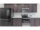 Close up of a modern kitchen featuring stainless steel appliances and gray cabinets at 5255 Peak Rock Ct, Las Vegas, NV 89141
