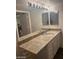 Bathroom featuring a granite-style countertop, dual mirrors, and vanity lighting at 555 E Silverado Ranch Blvd # 1123, Las Vegas, NV 89183
