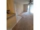 A living room with an outdated carpet, ceiling fan, and glass sliding door at 555 E Silverado Ranch Blvd # 1123, Las Vegas, NV 89183