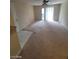 A living room with an outdated carpet, ceiling fan, and glass sliding door at 555 E Silverado Ranch Blvd # 1123, Las Vegas, NV 89183