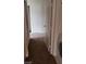 Hallway with neutral carpet leading to a room with a closet and a laundry area at 5750 E Hacienda Ave # 202, Las Vegas, NV 89122