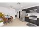 Modern kitchen adjacent to a dining area with stainless steel appliances, dark cabinetry, and light wood flooring at 6017 Montecito Way, Las Vegas, NV 89108