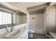 Bright bathroom with a large mirror, white vanity, and a combined shower and bathtub at 6873 Tamarus St # 201, Las Vegas, NV 89119