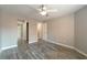 Neutral bedroom with wood-look floors, ceiling fan, and access to bathroom and closets at 6873 Tamarus St # 201, Las Vegas, NV 89119