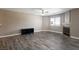 Spacious living room features wood-look flooring, modern fan, and a corner fireplace at 6873 Tamarus St # 201, Las Vegas, NV 89119