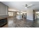 Open-concept living room with fireplace, ceiling fan, and wood-style floors flows to the kitchen at 6873 Tamarus St # 201, Las Vegas, NV 89119