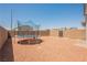 Spacious gravel backyard with a trampoline and privacy walls at 7002 Fossil Rim St, North Las Vegas, NV 89084