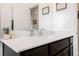 Bathroom featuring white countertop, dark cabinets, mirror and decorative accents at 7002 Fossil Rim St, North Las Vegas, NV 89084