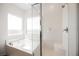 Bright and well lit bathroom with bathtub and glass-enclosed shower at 7002 Fossil Rim St, North Las Vegas, NV 89084