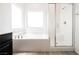 Bright bathroom features a soaking tub with a glass-enclosed shower and neutral decor at 7002 Fossil Rim St, North Las Vegas, NV 89084