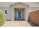 Charming covered front porch featuring a blue door and brick pathway at 7002 Fossil Rim St, North Las Vegas, NV 89084