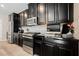 Close-up of kitchen with black cabinets, stainless steel appliances, and herringbone backsplash at 7002 Fossil Rim St, North Las Vegas, NV 89084