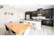 Modern kitchen featuring dark cabinetry, granite countertops, and a large dining table at 7002 Fossil Rim St, North Las Vegas, NV 89084
