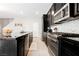 View of kitchen featuring black cabinetry, stainless steel appliances, and sleek countertops at 7002 Fossil Rim St, North Las Vegas, NV 89084