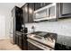 Kitchen with black cabinets, stainless steel appliances, countertops, and herringbone backsplash at 7002 Fossil Rim St, North Las Vegas, NV 89084