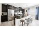 Modern kitchen with stainless steel appliances, a spacious island, and sleek black cabinetry at 7002 Fossil Rim St, North Las Vegas, NV 89084