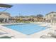 Community pool featuring several lounge chairs, tables, and umbrellas to relax and enjoy the sun at 7002 Fossil Rim St, North Las Vegas, NV 89084
