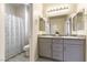 Well-lit bathroom with a double sink vanity, gray cabinets, and a shower-tub combo at 7265 Southern Magnolia St, Las Vegas, NV 89149