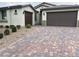 A well-maintained exterior of a single-story home with a three-car garage and desert landscaping at 7265 Southern Magnolia St, Las Vegas, NV 89149