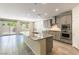 Contemporary kitchen with an island, stainless steel appliances, gray cabinetry, and sliding doors to the backyard at 7265 Southern Magnolia St, Las Vegas, NV 89149