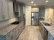 Open kitchen with gray cabinets, granite countertops, stainless steel appliances, and tile flooring at 7265 Southern Magnolia St, Las Vegas, NV 89149