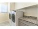 Bright laundry room with modern appliances and a countertop for folding at 7265 Southern Magnolia St, Las Vegas, NV 89149