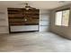 Open living room with wood accent wall, floating shelves, tile flooring, and lots of natural light at 7265 Southern Magnolia St, Las Vegas, NV 89149
