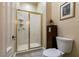 Bathroom showing a glass door shower, toilet, cabinet, neutral wall and tile, and framed art at 7718 Willow Cove Cir, Las Vegas, NV 89129