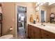 Bright bathroom featuring tiled floors and a vanity with a sink, mirror, and decorative lighting at 7718 Willow Cove Cir, Las Vegas, NV 89129
