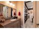 Bathroom featuring a granite countertop, framed mirror, and access to hallway with built-in bookshelf at 7718 Willow Cove Cir, Las Vegas, NV 89129
