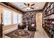 Library with wall-to-wall bookshelves, comfortable seating, and natural light from shuttered windows at 7718 Willow Cove Cir, Las Vegas, NV 89129