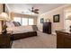 Comfortable main bedroom featuring carpet, paneled walls, and abundant natural light from large windows at 7718 Willow Cove Cir, Las Vegas, NV 89129
