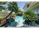 Private pool surrounded by lush palm trees, rock waterfall, and mature landscaping to create a tropical oasis at 7718 Willow Cove Cir, Las Vegas, NV 89129
