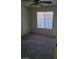 Bright bedroom featuring a ceiling fan, window, and neutral carpet, providing a cozy atmosphere at 7730 Secret Shore Dr # 207, Las Vegas, NV 89128