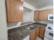 Kitchen area features stainless steel sink, granite countertops, and wooden cabinets at 7730 Secret Shore Dr # 207, Las Vegas, NV 89128