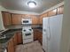 This kitchen features granite countertops, wooden cabinets, and white appliances at 7730 Secret Shore Dr # 207, Las Vegas, NV 89128