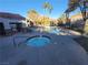 Community pool and jacuzzi with poolside furniture, palm trees, and beautiful landscaping at 7730 Secret Shore Dr # 207, Las Vegas, NV 89128