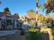 Community pool area with palm trees, lush green shrubs, and a tile-roof cabana at 7730 Secret Shore Dr # 207, Las Vegas, NV 89128