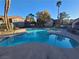 Community pool surrounded by tropical trees and nearby apartment buildings at 7730 Secret Shore Dr # 207, Las Vegas, NV 89128