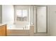 Clean bathroom featuring a tub, shower and a large window at 8109 Retriever Ave, Las Vegas, NV 89147