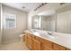 Bright bathroom features a double sink vanity, large mirror, and window with natural light at 8109 Retriever Ave, Las Vegas, NV 89147