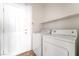 Bright laundry room features a washer, dryer, shelving and exterior access to the side yard at 8109 Retriever Ave, Las Vegas, NV 89147