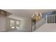 Bright living room featuring large windows and a decorative chandelier near the staircase at 8109 Retriever Ave, Las Vegas, NV 89147