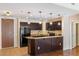 Modern kitchen featuring dark cabinets, granite countertops, and stylish pendant lighting at 8255 Las Vegas Blvd # 117, Las Vegas, NV 89123