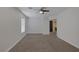 Bedroom features neutral paint, plush carpeting, ceiling fan, and window at 829 Dancing Vines Ave, Las Vegas, NV 89183
